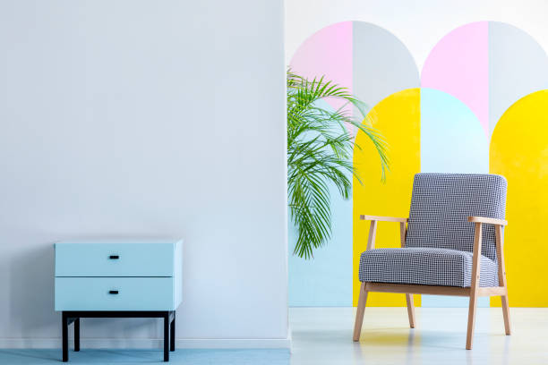 istock Real photo of a spacious, pastel office interior with mint cupboard standing against white wall with copy space next to an armchair with houndstooth pattern 1030632030