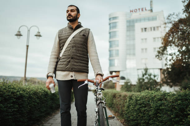 istock Young man with a bicycle enjoying a coffee break in the public park 1030632100