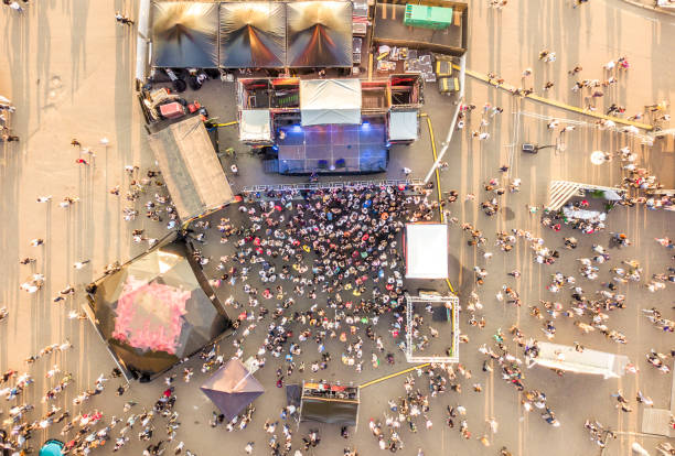 aerial top view of crowd of people standing near the stage on concert on summer day aerial top view of crowd of people standing near the stage on a concert on summer day film festival photos stock pictures, royalty-free photos & images