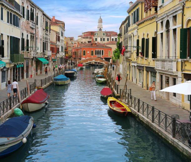 Charming Venetian canal street with colorful boats stock photo