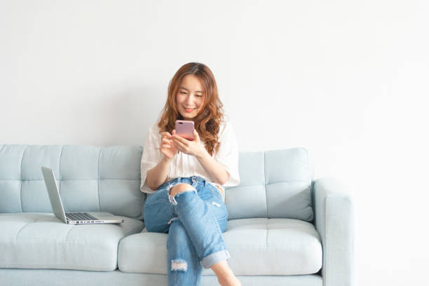 istock Pretty asian woman using smart phone at home 1030675328