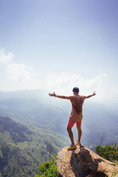 istock Hiker stands on che rock cliff in the mountains 1030683278