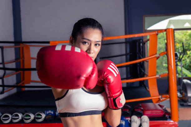 istock Attractive Female Punching A Bag With Boxing Gloves On 1030683766