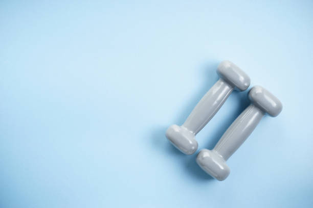 istock two gray dumbbells on light blue background 1030686958