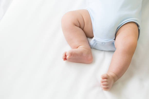 istock leg of baby lying on the white bed 1030702992