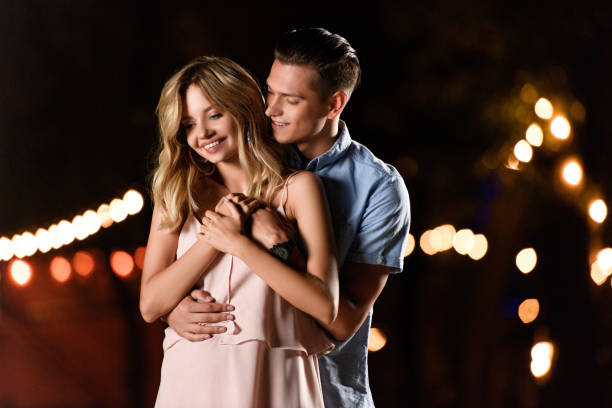 istock boyfriend hugging smiling girlfriend on river beach in evening 1030725852