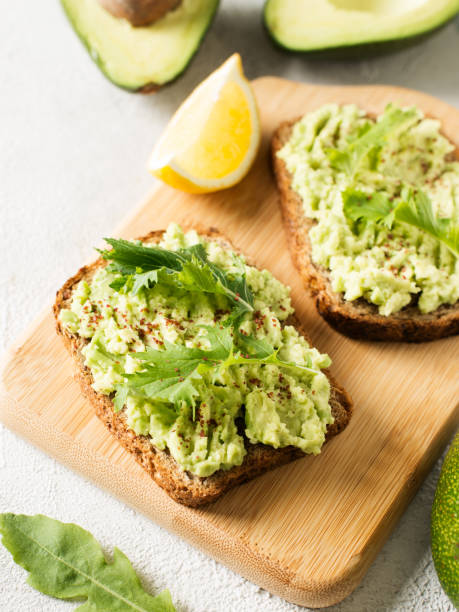 istock Two toasts with avocado and green salad on breakfast 1030734026