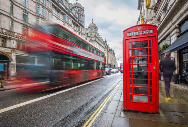 istock London, England - Iconic blurred red double-decker bus on the move with traditional red telephone box 1030743246