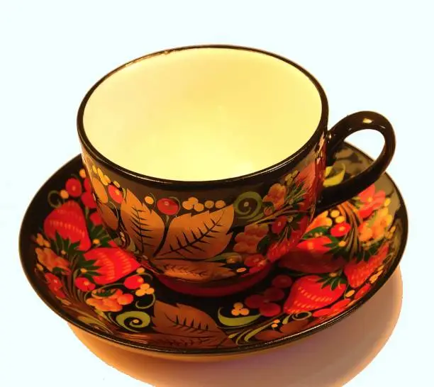 Porcelain cup and saucer from a tea set covered in Russian style in Khokhloma.