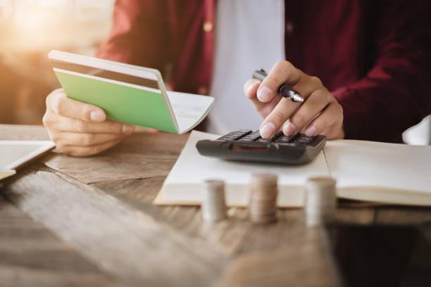 istock Business Accounting hands holding saving account passbook with calculator, account and saving concept. 1030744454