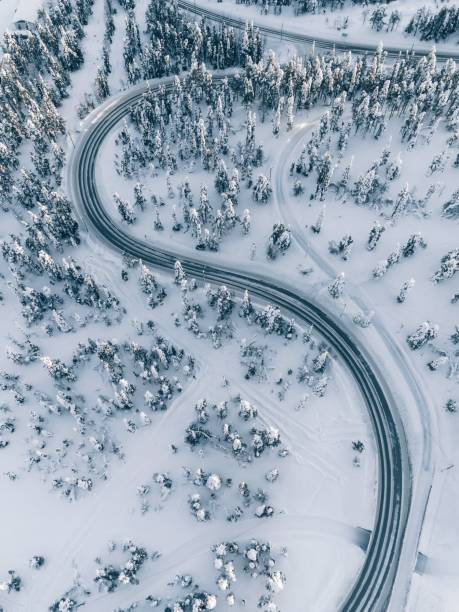 luftaufnahme des winter-straße in den wald mit schnee bedeckt, finnland lappland - snow winter mountain horizon over land stock-fotos und bilder