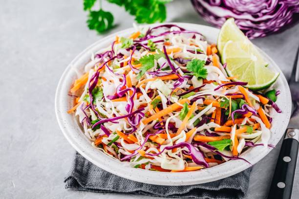 istock Cilantro lime coleslaw salad with red and white cabbage on stone background 1030747278