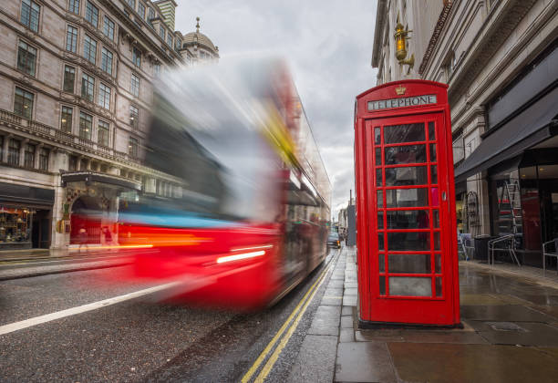 istock London, England - Iconic blurred red double-decker bus on the move with traditional red telephone box 1030748524