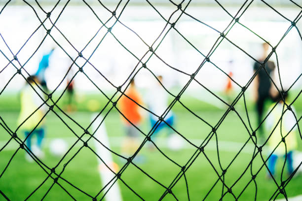 istock Soccer training net blur on training ground with children 1030750958