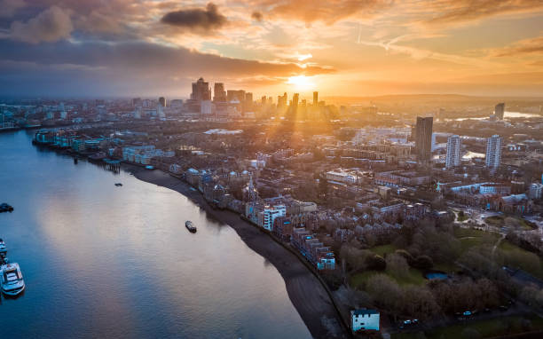 London, England - Panoramic aerial skyline view of east London at sunrise with skycrapers of Canary Wharf London, England - Panoramic aerial skyline view of east London at sunrise with skycrapers of Canary Wharf and beautiful colorful sky at background sunrise dawn stock pictures, royalty-free photos & images