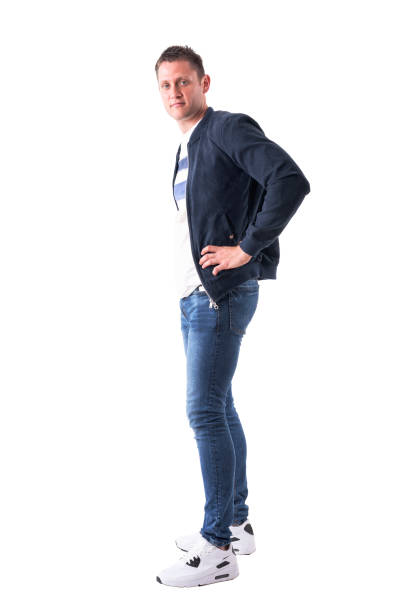 istock Side view of relaxed confident man with hands on hips in bomber jacket looking at camera 1030751804