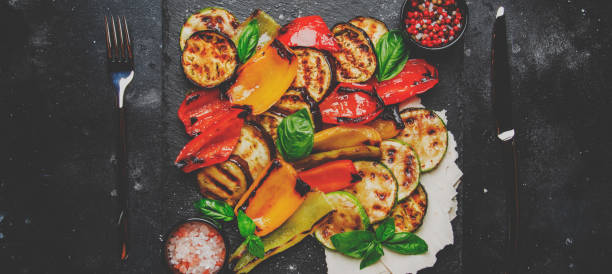 istock Grilled multicolored vegetables, aubergines, zucchini, pepper with green basil on serving stone board 1030752214