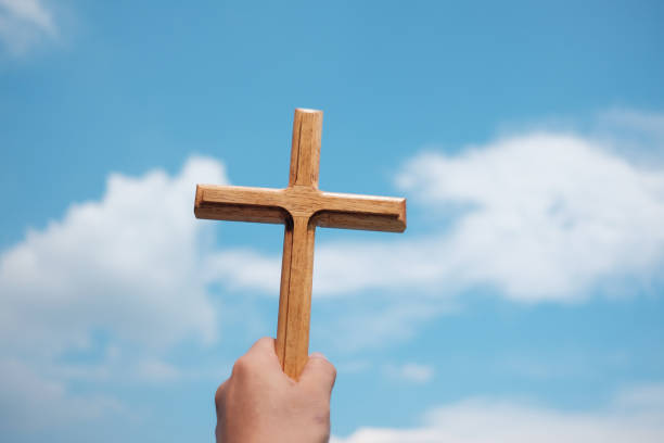 istock Cross in hand holding up the sky. 1030759464