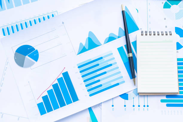 istock Pen and Notebook on Business Graphs finance document. 1030770274