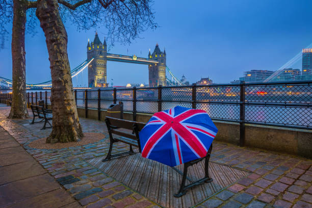 istock London, England - British style umbrella on a bench with iconic illuminated Tower Bridge 1030770756