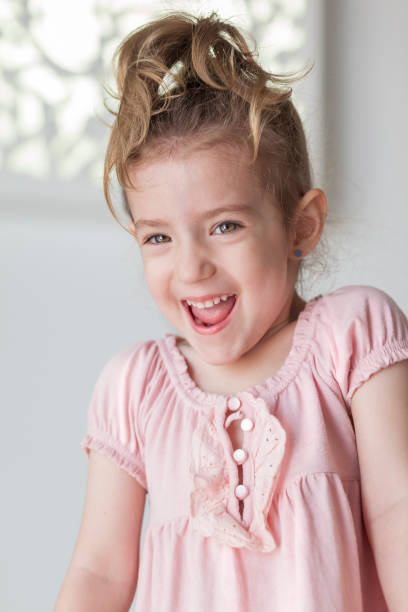 istock Little blonde girl looking at camera laughing 1030773024