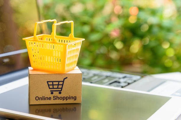 Mini orange shopping basket on a smart device and a laptop with boxes. Concept of shopping that client can buy or purchase goods or products from websites worldwide over internet by just a few clicks. mini cesta naranja en un dispositivo inteligente y un ordenador portátil con las cajas. concepto de compras a que el cliente puede comprar o adquirir bienes o productos de los sitios web en todo el mundo por internet por sólo unos pocos clics.