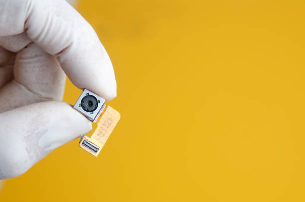 istock Hand with rubber gloves holding smartphone camera lens part 1030773854
