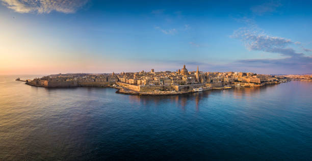 Valletta, Malta - Aerial panoramic skyline of Valletta at sunrise with Our Lady of Mount Carmel church and St.Paul's Cathedral Valletta, Malta - Aerial panoramic skyline of Valletta at sunrise with Our Lady of Mount Carmel church and St.Paul's Anglican Cathedral valletta photos stock pictures, royalty-free photos & images