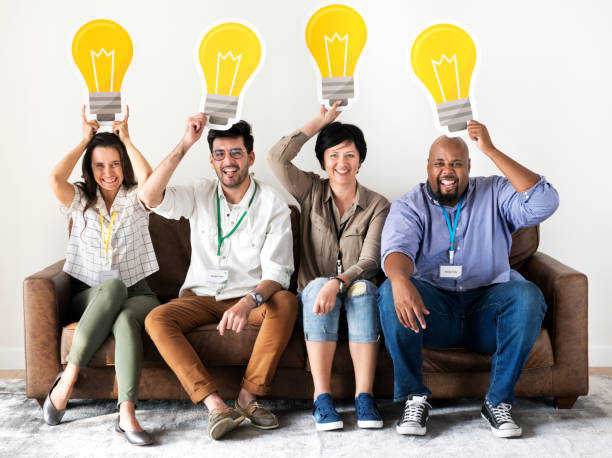 Workers sitting and holding light bulb icons