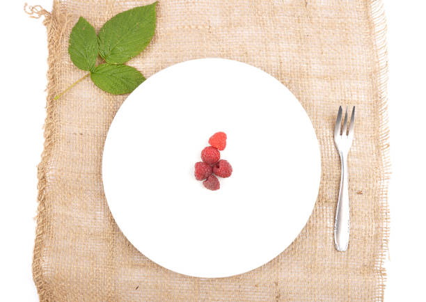 istock Red raspberries on plate and jute 1030780798