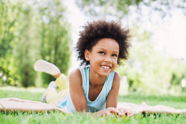 istock Beautiful little kid girl lying on a grass 1030783260