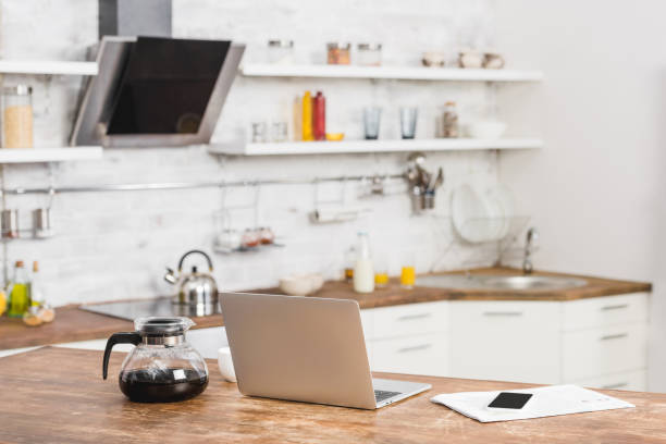 istock laptop, smartphone and coffee pot on kitchen counter 1030783564