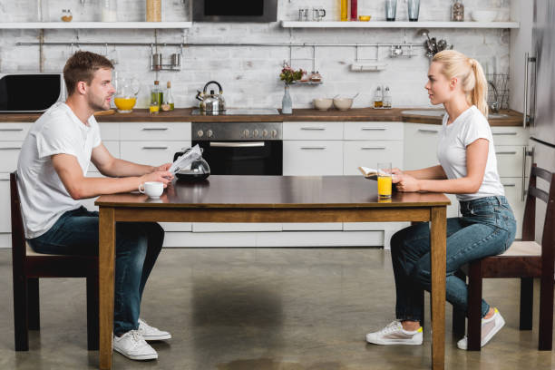 istock side view of young couple reading and looking at each other while having breakfast together 1030784002