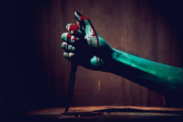 Halloween concept with Bloody stabbing. Hand with knife