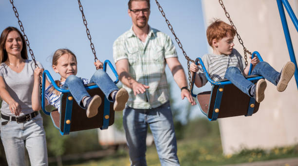 istock couple with two children playing in the Playground 1030791176