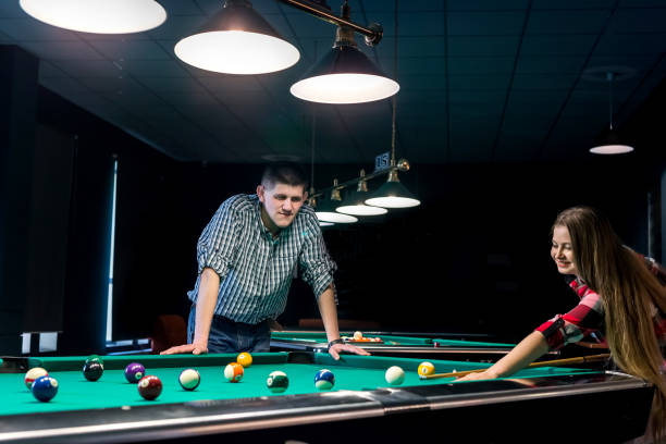 istock Beautiful smiling couple in pub playing billiard 1030803206