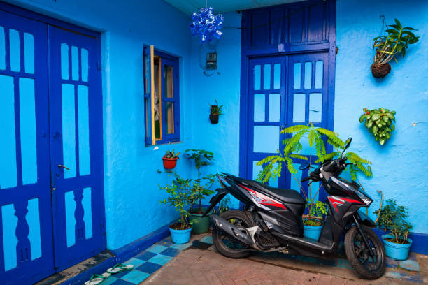 casa blu con moto parcheggiata nel villaggio kampung biru arema - arema foto e immagini stock