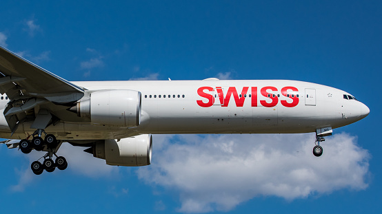 Zurich, Switzerland - August 26, 2018: A Boeing 777-3DEER of Swiss International Airlines approaching Runway 14 of Zurich Airport. The long-haul aircraft with registration HB-JNG was delivered to the Swiss airline on 15 February 2017. The photo was taken outside the airport.