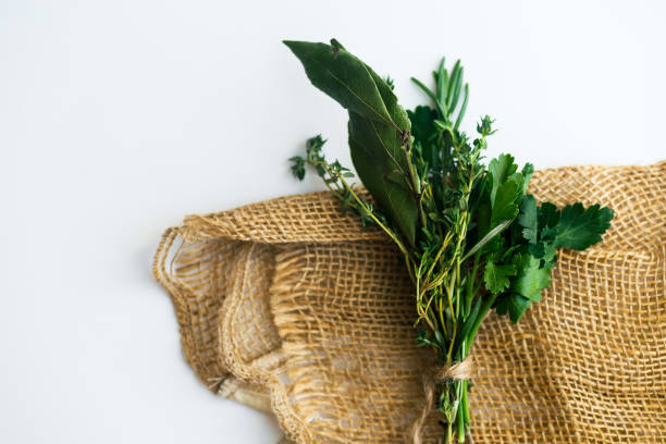 bouquet garni com folhas de louro e frescas ervas de provence na toalha rústica sobre fundo branco, com espaço de cópia - herb bouquet garni herbes de provence bouquet - fotografias e filmes do acervo