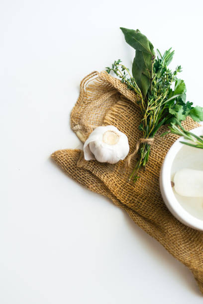 bouquet garni com folhas de louro e frescas ervas de provence na toalha rústica em fundo branco com alho cravo e argamassa - herb bouquet garni herbes de provence bouquet - fotografias e filmes do acervo