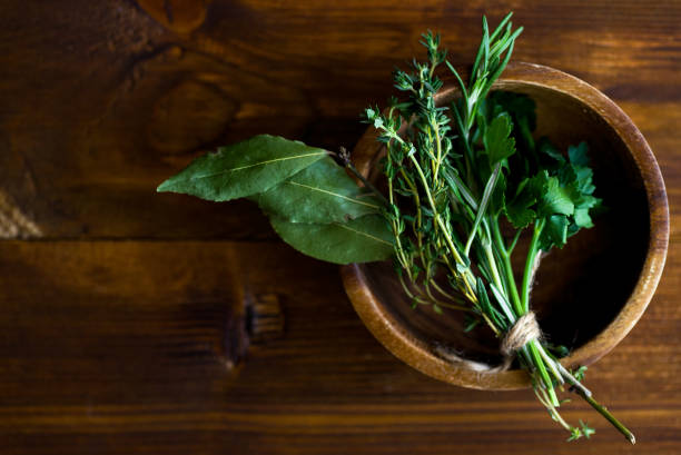 bouquet garni com folhas de louro e frescas ervas de provence, no fundo escuro de madeira - herb bouquet garni herbes de provence bouquet - fotografias e filmes do acervo