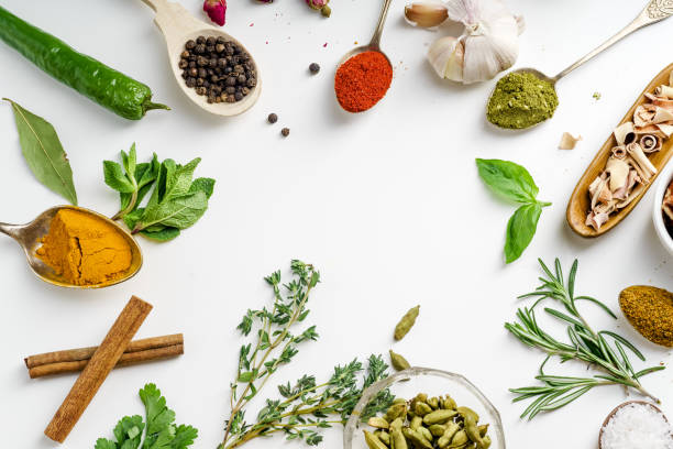 istock Fresh herbs and dried colorful spices in spoons and bowls arranged in frame on white background with copy space inside 1030808744
