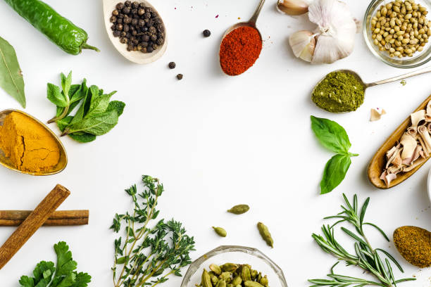 istock Fresh herbs and dried colorful spices in spoons and bowls arranged in frame on white background with copy space inside 1030808792