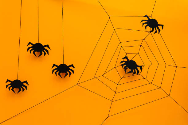 istock Black paper spider with web on yellow background. Halloween concept. Paper cut style. Top view 1030808954