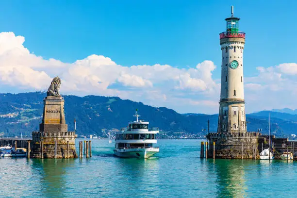 Scenic summer view of the lighthouse and lion statue in the harbor of the Old Town of Lindau on Bodensee or Constance lake in Bavaria, Germany