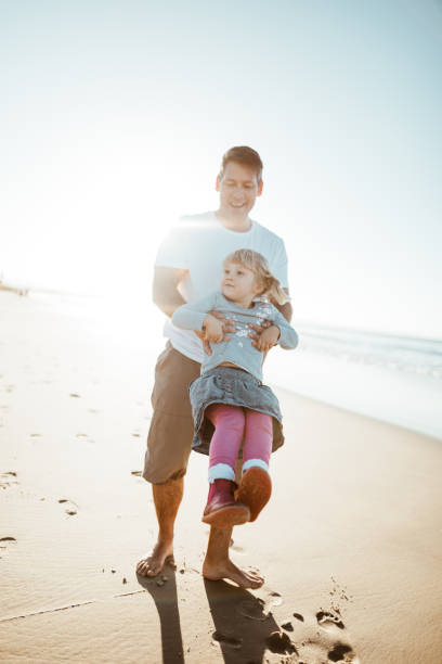 istock lovely daughter playing at the beach with the dad 1030822924