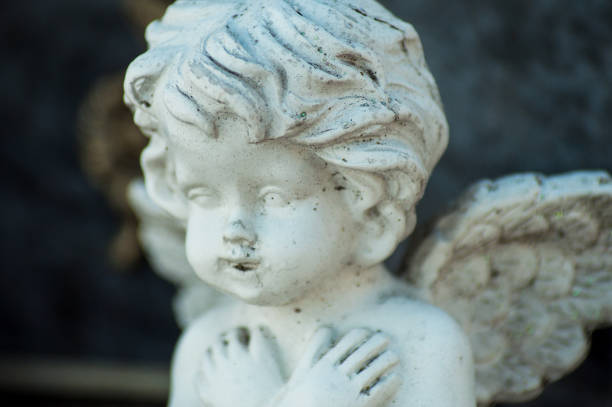 istock stoned angel on tomb in cemetery 1030827236