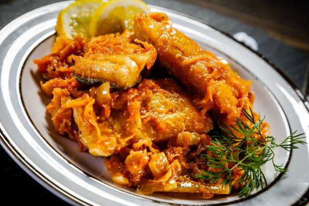 istock Fish in vegetable sauce on wooden background 1030828050