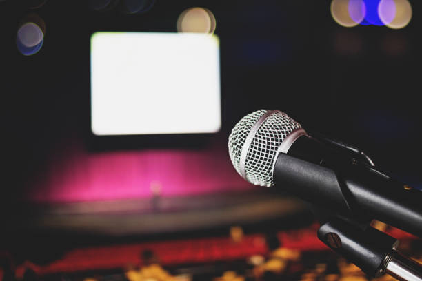 istock Microphone on blur stage and hall background, Music and singing concept 1030832742