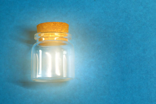 istock glass jar with glow on a blue background 1030836628